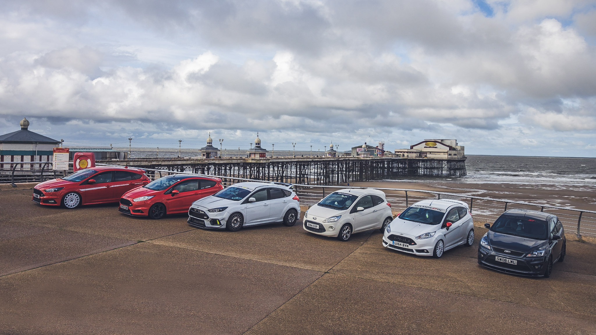 Group of cars parked on a hillside.